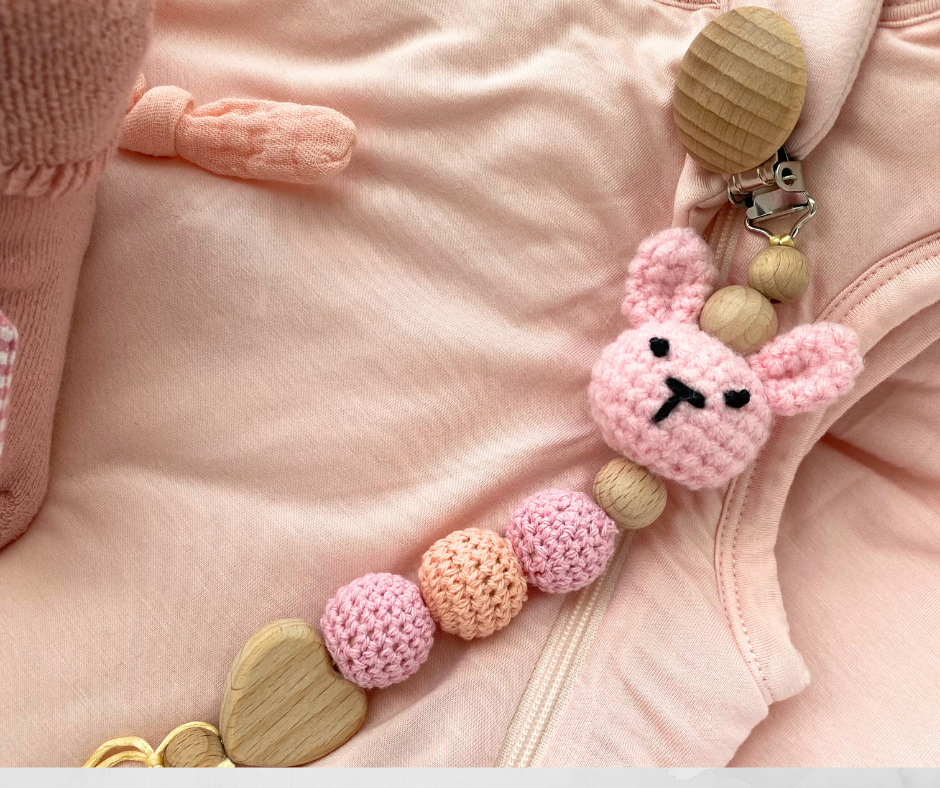 Pink crochet bunny with wooden and fabric beads on a pink background